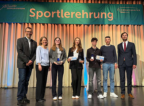 Männer und Frauen auf der Bühne.